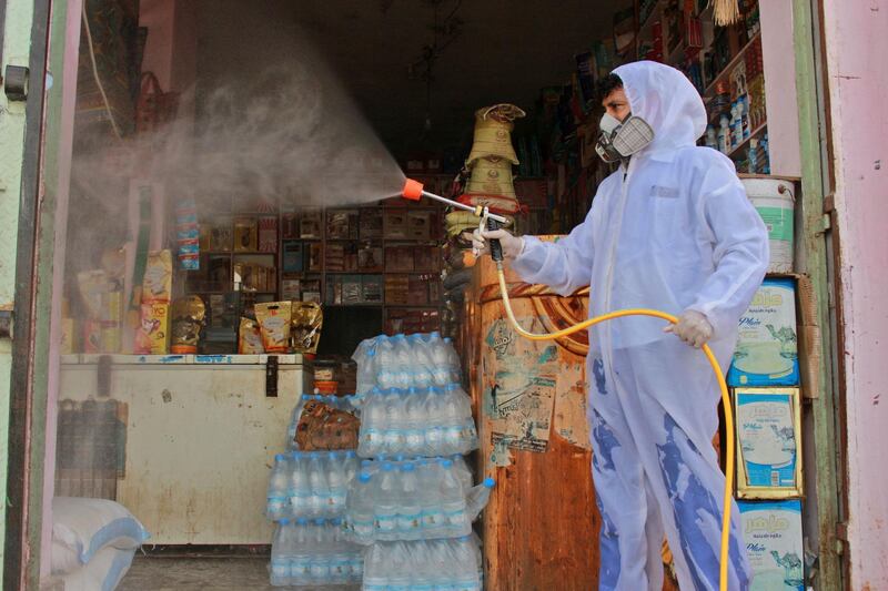 A Yemeni sanitation worker, wearing protective gear, sprays disinfectant in a neighbourhood in the northern Hajjah province.  AFP