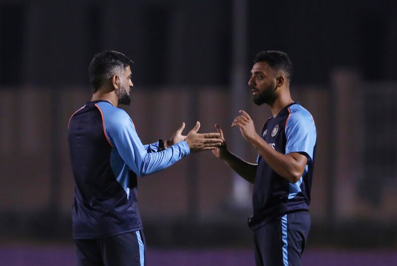 Team India mentor MS  Dhoni, left, talks with Varun Chakravarthy during a training session. AP