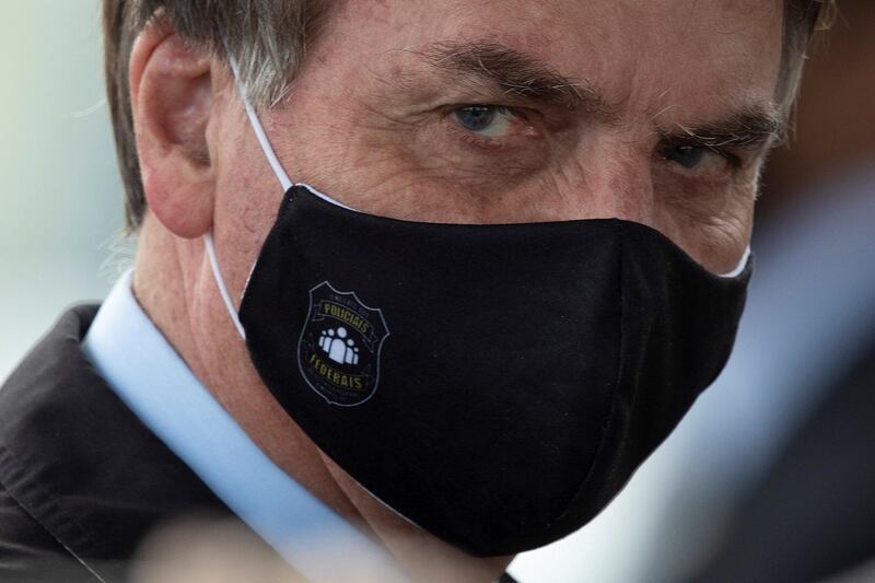 epa08443524 The president of Brazil, Jair Bolsonaro, leaves the Palacio da Alvorada (Presidential residence) to see dozens of his supporters, in Brasilia, Brazil, 25 May 2020. Brazil has the second most confirmed cases of COVID-19 worldwide.  EPA/Joedson Alves