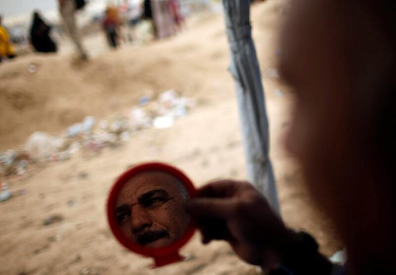 A member of the Iraqi Federal Police is seen reflected at mirror as he shaves outside Hammam al-Alil camp south of Mosul, Iraq. Suhaib Salem / Reuters