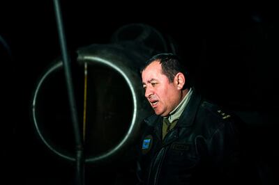 Albanian fighter jet pilot and former airforce commander Fatmir Danaj, 52, speaks with an AFP journalist in front of a MiG-19 jet fighter, inside the main tunnel of the Gjader Air Base built near the city of Lezhe on February 5, 2019. On a barren hillside in northern Albania lies a portal to the country's communist past: a massive steel door creaks open to reveal a hidden former air base burrowed into the heart of the mountain. Made up of 600 metres (1,980 feet) of tunnels that once teemed with military life, the secret Gjader air base is now a depot for dozens of hulking communist-era MiG jets collecting dust in the darkness. Three decades after shedding communism, Albanian authorities are still trying to sell off the Soviet and Chinese-made aircraft, of which there are dozens more in another nearby air base.
 / AFP / Gent SHKULLAKU
