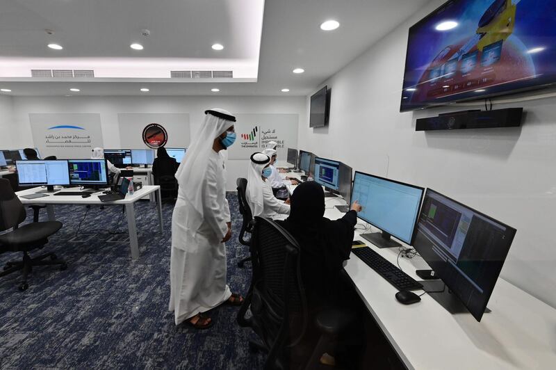 Emiratis are pictured at the Mohammed Bin Rashid Space Centre in Dubai on July 19, 2020, ahead of the expected launch of the "Hope" Mars probe from Japan. The probe is one of three racing to the Red Planet, with Chinese and US rockets also taking advantage of the Earth and Mars being unusually close: a mere hop of 55 million kilometres (34 million miles). "Hope" -- Al-Amal in Arabic -- is expected to start orbiting Mars by February 2021, marking the 50th anniversary of the unification of the UAE. / AFP / Giuseppe CACACE
