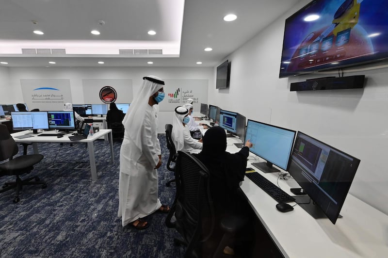 Emiratis are pictured at the Mohammed Bin Rashid Space Centre in Dubai on July 19, 2020, ahead of the expected launch of the "Hope" Mars probe from Japan. The probe is one of three racing to the Red Planet, with Chinese and US rockets also taking advantage of the Earth and Mars being unusually close: a mere hop of 55 million kilometres (34 million miles). "Hope" -- Al-Amal in Arabic -- is expected to start orbiting Mars by February 2021, marking the 50th anniversary of the unification of the UAE. / AFP / Giuseppe CACACE
