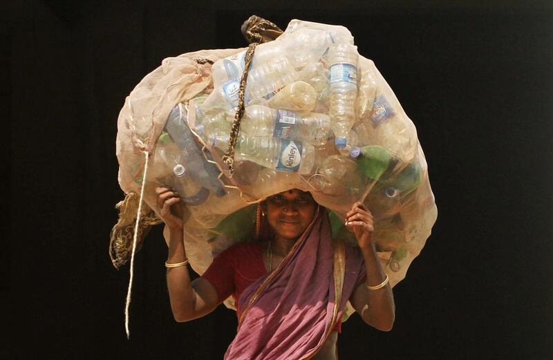 A woman carries a sack of used plastic bottles to be sold at a recycled plant on the International Woman’s Day in the eastern Indian city of Bhubaneswar.  Biswaranjan Rout / AP Photo