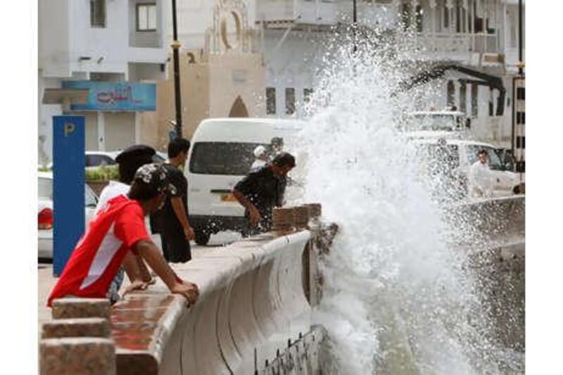 Omanis watch the waves hitting against the seawall along the Muscat Corniche yesterday, as they brace for a possible strike from Cyclone Phet.