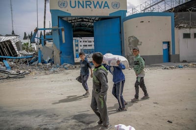 Children carry bags of flour after aid was distributed in Gaza city on March 17. AFP