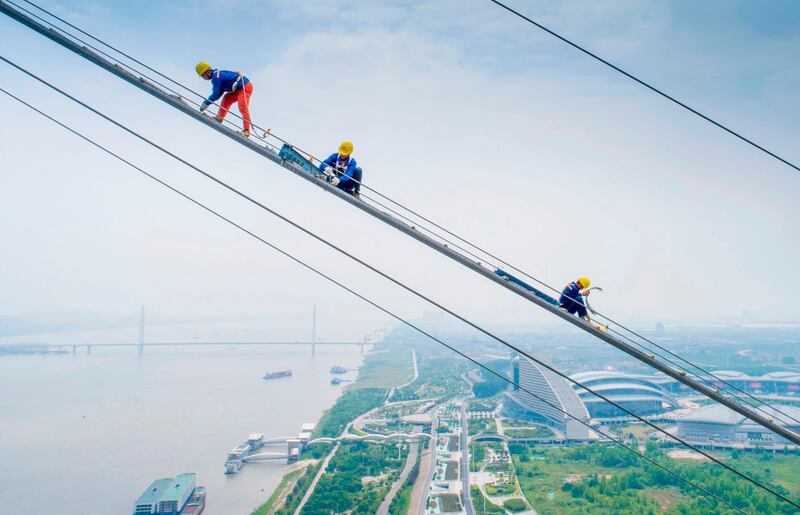 This photo taken with a drone shows labourers work on the construction of a double-deck suspension bridge crossing the Yangtze River in Wuhan in cental China. AFP
