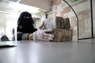 An employee takes bundles of Yemeni Riyal at the Central Bank of Yemen in Sanaa. REUTERS