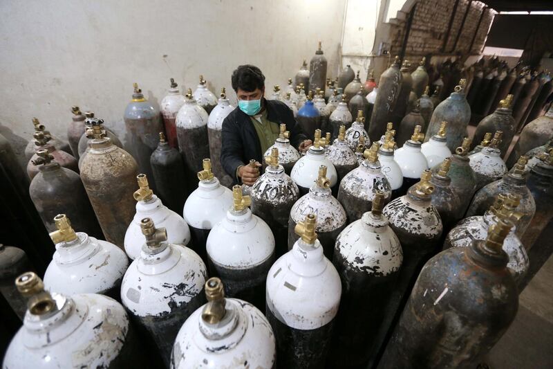 A worker counts oxygen tanks in a factory amid shortage of oxygen cylinders as Covid-19 cases rise, in Peshawar, Pakistan.   EPA