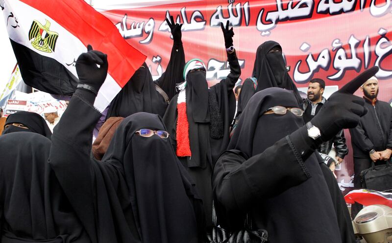 Egyptian women wearing the 'Niqab',  shouts slogans during a rally in Cairo's Tahrir square, Egypt, Friday, Nov.18, 2011 in a protest against what they say are attempts by the country's military rulers to reinforce their powers. The rally Friday was dominated by the country's most organized political group, the Muslim Brotherhood. It was called to protest a document floated by the government which declares the military the guardian of 'constitutional legitimacy,' suggesting the armed forces could have the final word on major policies. Arabic read " The prophet Mohammad, peace be upon him" .   (AP Photo/Amr Nabil) *** Local Caption ***  Mideast Egypt.JPEG-04f30.jpg