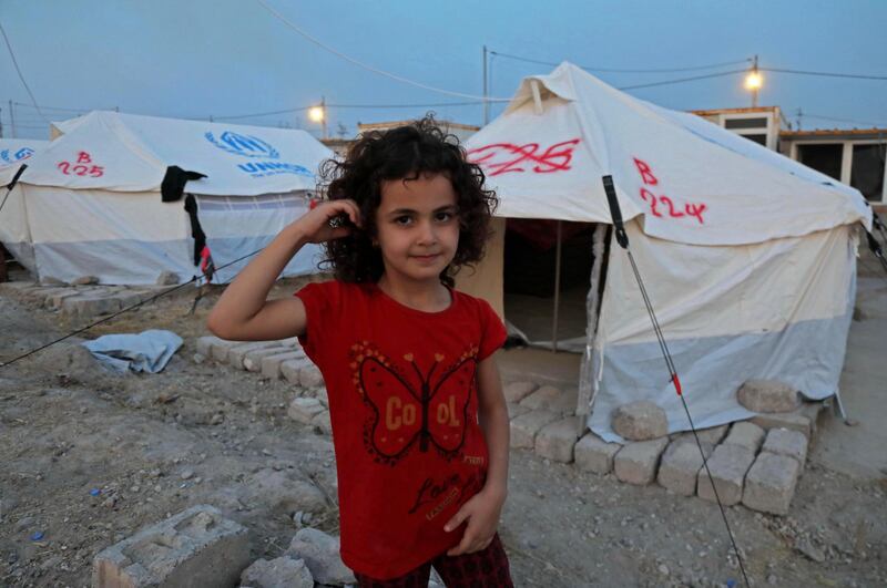 A Syrian girl recently-turned refugee by the Turkish military operation in northeastern Syria stands outside a tent at the Bardarash camp, near the Kurdish city of Dohuk, in Iraq's autonomous Kurdish region.  AFP