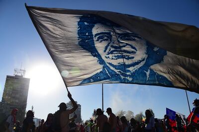 A demonstrator flutters a flag depicting Chilean musician Victor Jara during a protest against the government in Santiago on November 15, 2019. Chile announced Friday it will stage a referendum to replace the country's dictatorship-era constitution -- a key demand of protesters after nearly a month of sometimes violent civil unrest. / AFP / Johan ORDONEZ                      
