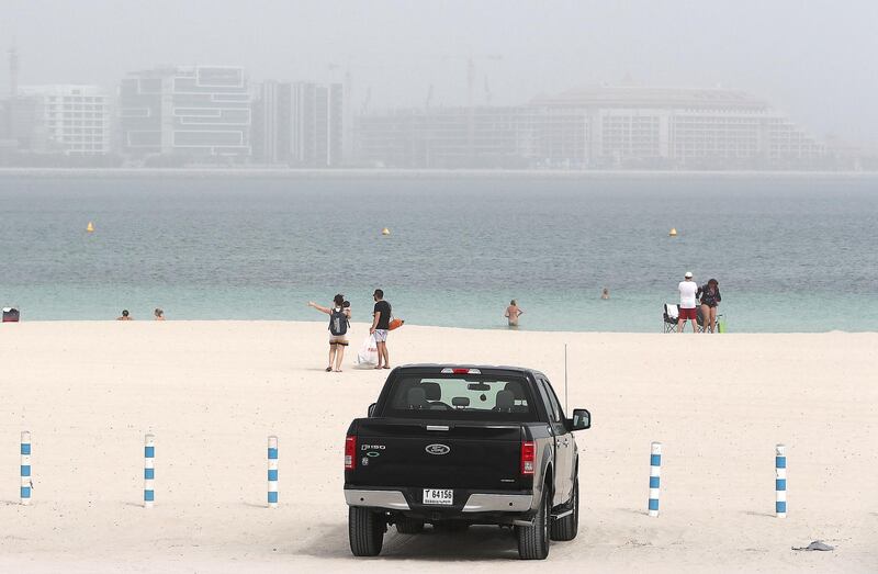 DUBAI , UNITED ARAB EMIRATES , APRIL 23  – 2018 :- People at the Jumeirah open beach during the sandstorm in Dubai. ( Pawan Singh / The National ) For News. 