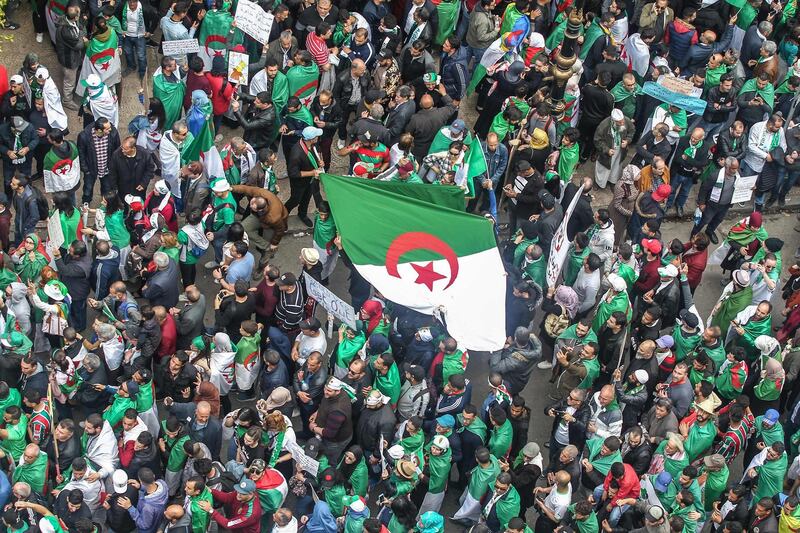 TOPSHOT - Algerians gather during an anti-government demonstration in the capital Algiers on April 5, 2019. Algerians were gathered today for the first mass protests since the resignation of ailing president Abdelaziz Bouteflika, in a key test of whether the momentum for reform can be maintained. Opponents of the old regime have called for a massive turnout, targeting a triumvirate they dub the "3B" -- Abdelakder Bensalah, Tayeb Belaiz and Prime Minister Noureddine Bedoui. / AFP / -
