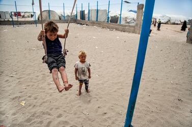 A boy plays on a swing at al-Hol camp, which houses families of members of the Islamic State group, in Hasakeh province, Syria, Saturday, May 1, 2021. It has been more than two years that some 27,000 children have been left to languish in al-Hol camp. Most of them not yet teenagers, they are spending their childhood in a limbo of miserable conditions with no schools, no place to play or develop and seemingly no international interest in resolving their situation. (AP Photo/Baderkhan Ahmad)