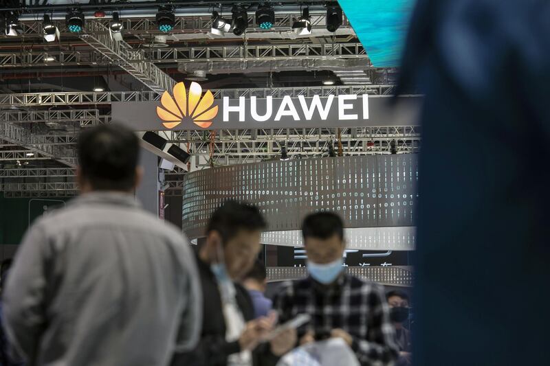Visitors walk past a logo at the Huawei Technologies Co. booth at the Auto Shanghai 2021 show in Shanghai, China, on Tuesday, April 27, 2021. The Shanghai International Automobile Industry Exhibition kicked off on April 19 in China's financial hub, a multiday event aimed at showcasing the best and brightest car innovations in the worlds biggest vehicle market. Photographer: Qilai Shen/Bloomberg