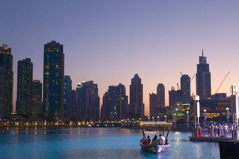 Tourists take a boat ride at the Burj Khalifa lake in Dubai. Satish Kumar / The National