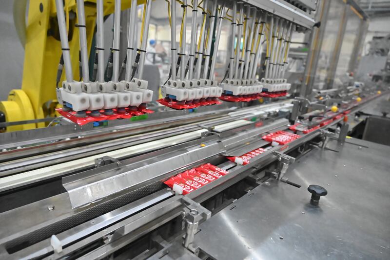 Grippers on the manufacturing line lift the packaged KitKats to transfer them on to a new conveyor belt. 