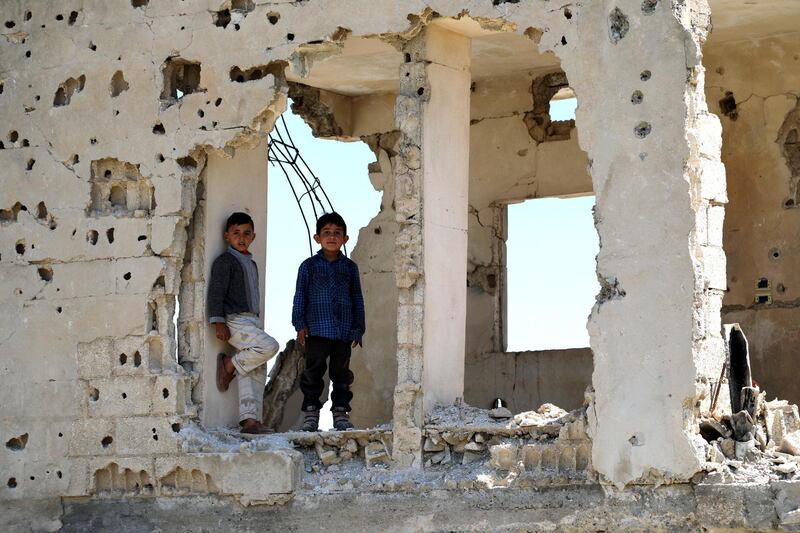 epa07534270 Syrian Kurdish boys look through a destroyed building in Kobani, the Kurdish region in the Aleppo Governorate in northern Syria, 26 April 2019 (issued on 28 April 2019). In January 2015 Kurdish forces of the Peopleâ€™s Protection Units (YPG) and Womenâ€™s Protection Units (YPJ) along with the Free Syria Army (FSA) and Peshmerga forces backed by US-led airstrikes, liberated Kobani town after months of fighting against the Islamic state (IS) group.  EPA/AHMED MARDNLI