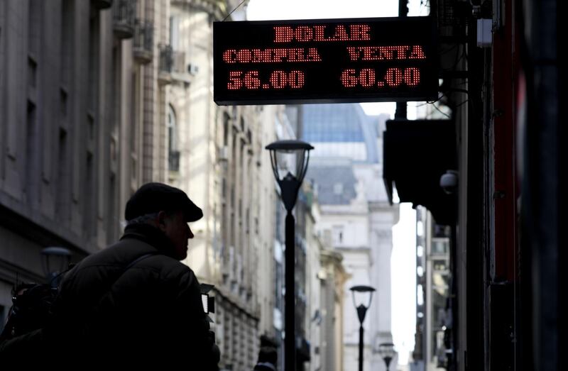 A man looks at a currency exchange board in Buenos Aires, Argentina, Monday, Aug. 12, 2019. Argentine stocks and currency plummeted on Monday after Argentine President Mauricio Macri was snubbed by voters who appeared to hand a resounding primary victory to a populist ticket with his predecessor, Cristina FernÃ¡ndez. (AP Photo/Natacha Pisarenko)