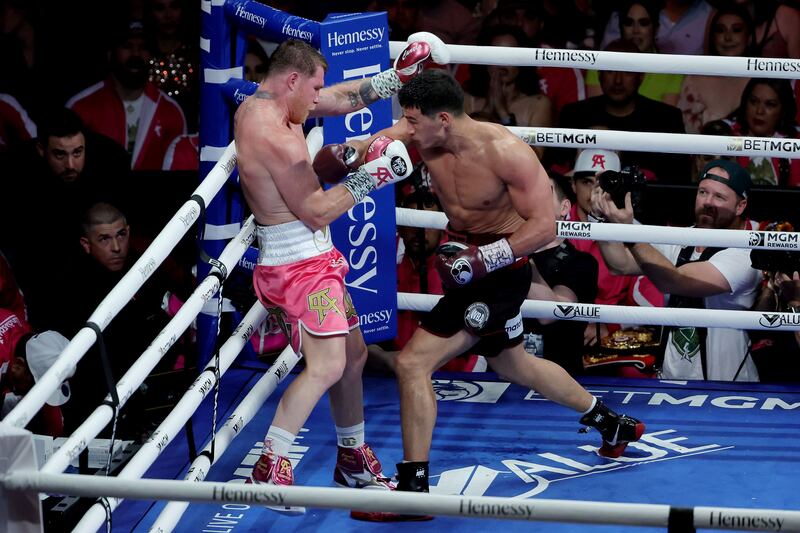 Dmitry Bivol exchanges punches with Canelo Alvarez during their WBA light heavyweight title fight at T-Mobile Arena.