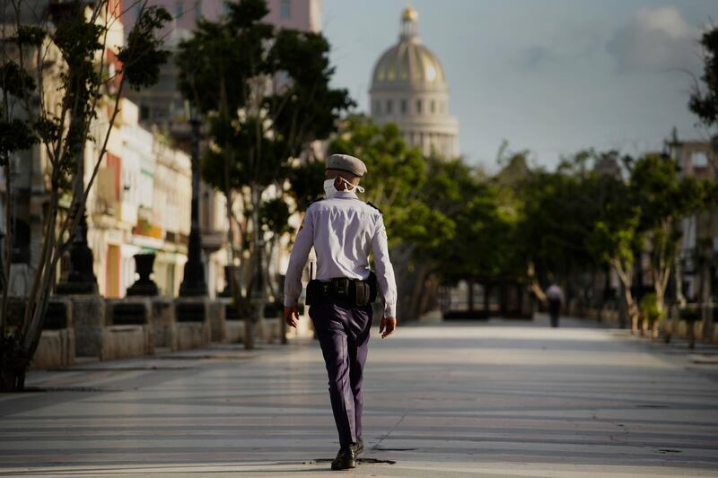 A police officer patrols near the Capitol during curfew in Havana, Cuba. AP Photo