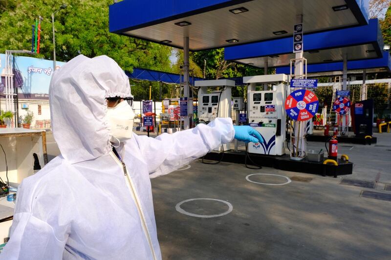 An employee wearing personal protective equipment (PPE) directs a customer at a Hindustan Petroleum Corp. gas station during a lockdown imposed due to the coronavirus in New Delhi, India. Oil has lost almost 80% this year as global efforts to stem the spread of the coronavirus vaporized demand for everything from gasoline to crude. The world's biggest producers have pledged to slash daily output from the start of next month to try and balance the market, but the collapse in consumption has led to a swelling glut that's testing the limits of storage worldwide. Bloomberg