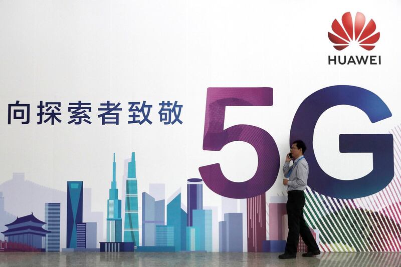 FILE PHOTO: A man talks on his mobile phone beside Huawei's billboard featuring 5G technology at the PT Expo in Beijing, China, September 26, 2018. To match Special Report HUAWEI-USA/CAMPAIGN REUTERS/Stringer/File Photo   ATTENTION EDITORS - THIS IMAGE WAS PROVIDED BY A THIRD PARTY. CHINA OUT.