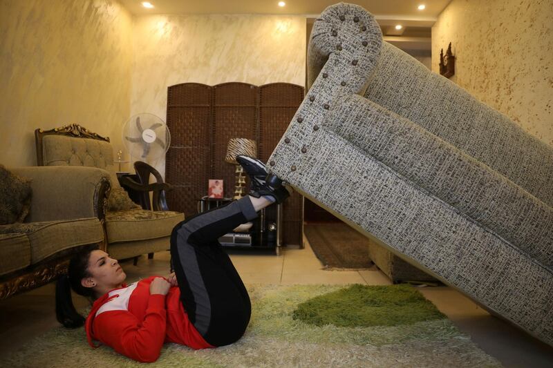 Hadeel Alami, a Jordanian judo practitioner, uses the sofa as a part of her trainings at her home during the curfew imposed by the government amid concerns over the spread of the coronavirus disease (COVID-19), in Amman, Jordan, April 9, 2020. REUTERS/Muhammad Hamed