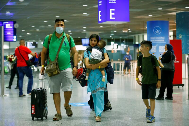 People walk with their bags upon arrival at Frankfurt Airport, Germany, after being evacuated from Kabul.