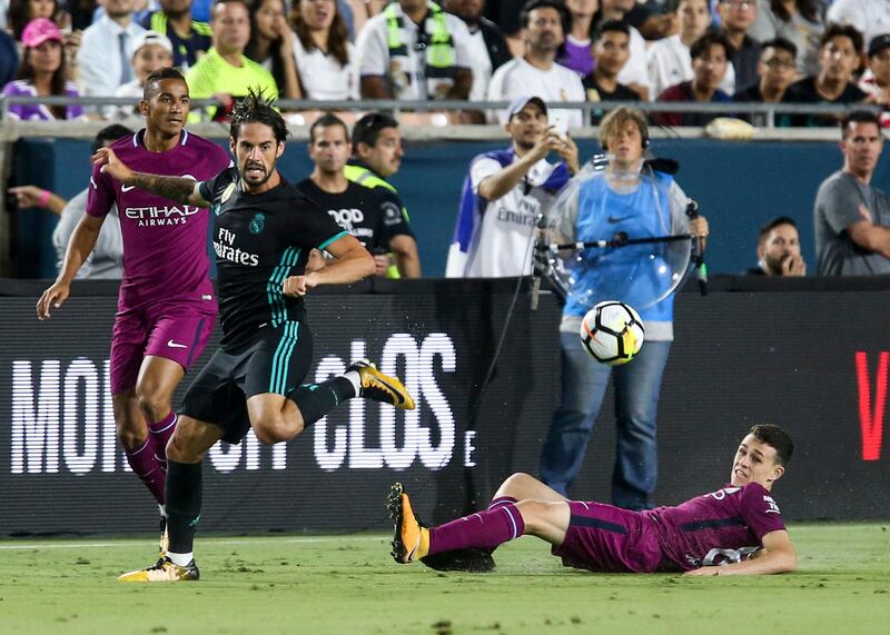 Manchester City midfielder Phil Foden, right eyes the ball with Isco of Real Madrid. Ringo Chiu / AFP