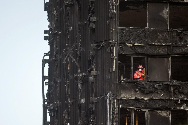 A fireman looks out from the remains of the Grenfell Tower in London at the weekend. Will Oliver / EPA