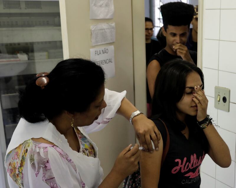 A health agent vaccinates people during a campaign of vaccination against yellow fever in Sao Paulo, Brazil October 24, 2017. REUTERS/Paulo Whitaker