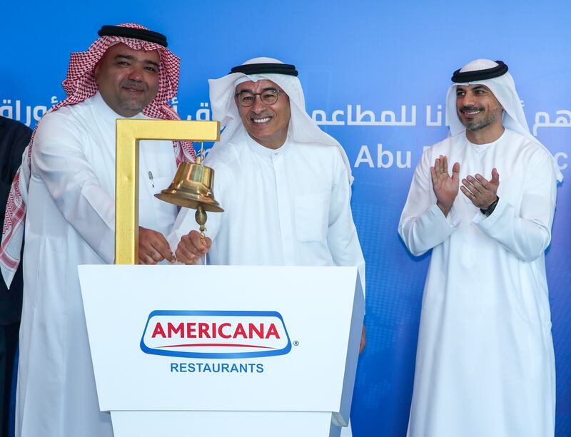 Americana Restaurants chairman Mohamed Alabbar (centre) and the company's vice chairman Abdulmalik Al-Hogail ring the bell at the debut of the company's shares on the Abu Dhabi Securities Exchange (ADX) as Hisham Malak, chairman of ADX looks on. Americana, founded in Kuwait in 1964, introduced fast-food restaurants in the region in 1970. Photo: Victor Besa / The National