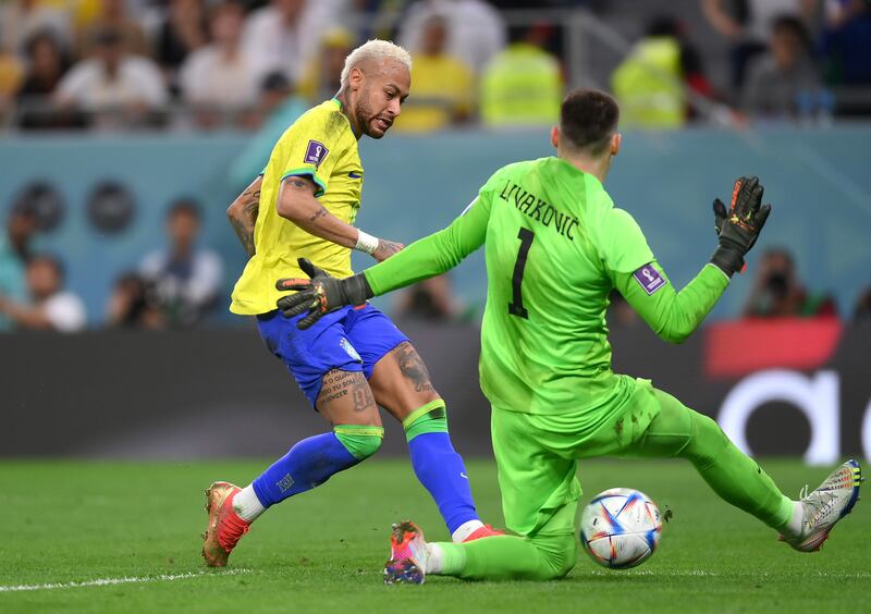 Croatia goalkeeper Dominik Livakovic saves from Neymar of Brazil. Getty