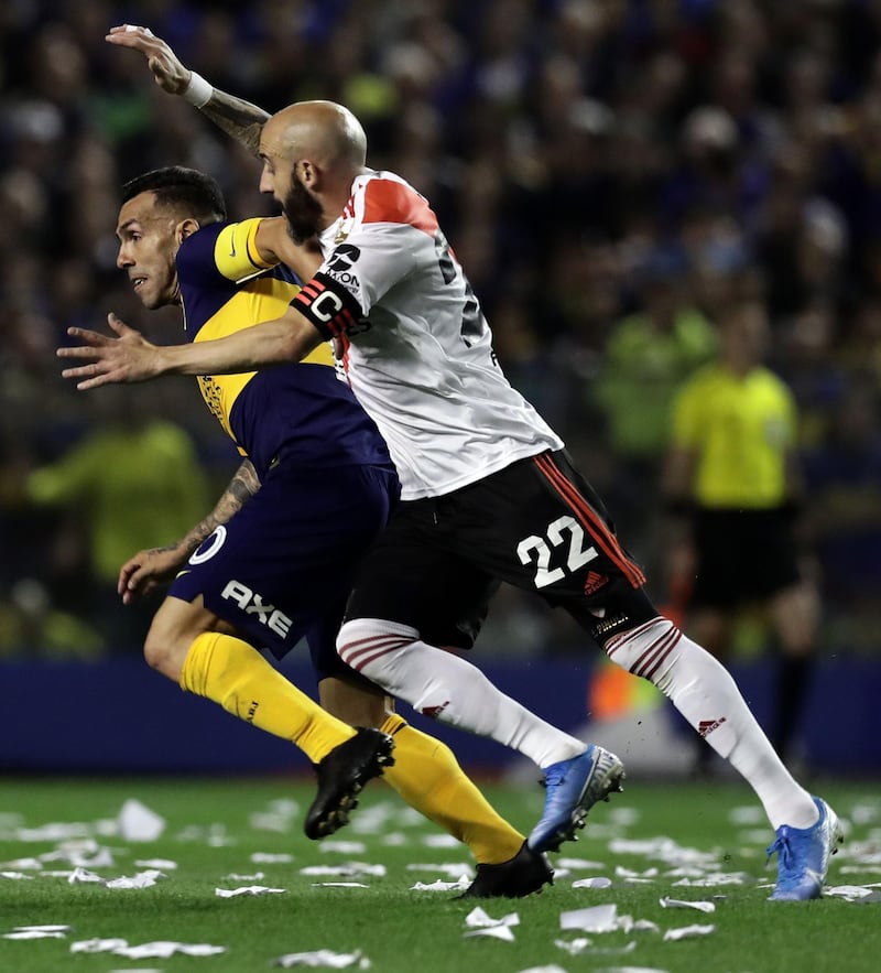 Boca Juniors' Carlos Tevez (L) is challenged by River Plate's Javier Pinola during their all-Argentine Copa Libertadores semi-final second leg football match at La Bombonera stadium in Buenos Aires, on October 22, 2019. / AFP / Alejandro PAGNI
