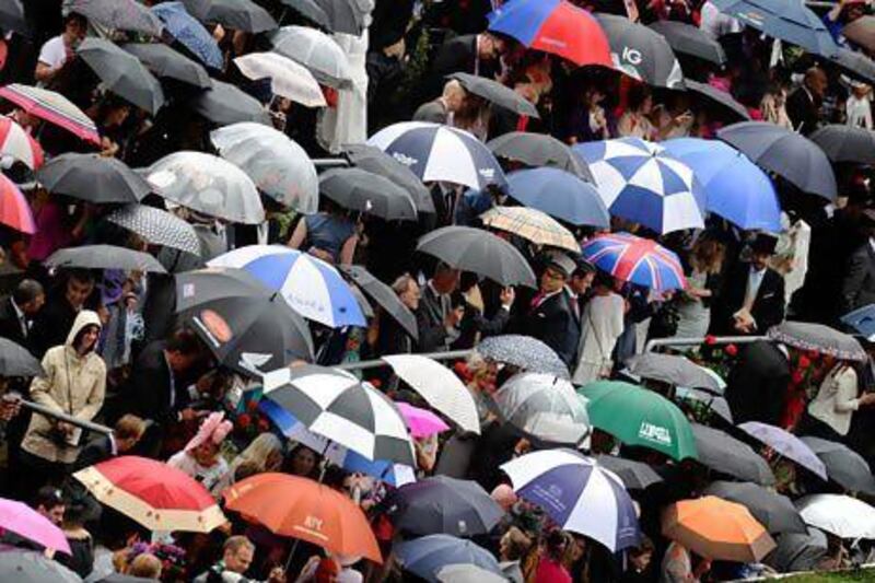 Racegoers shelter from the rain at Royal Ascot. The UK's poor weather is encouraging demand for foreign holidays. Alan Crowhurst / Getty Images