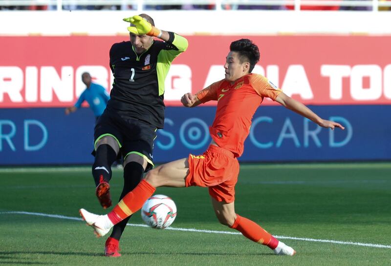 Kyrgyzstan's goalkeeper Matiash clears the ball under pressure from Wu Lei. AP Photo