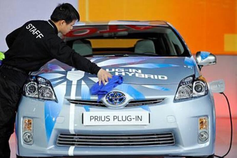 TO GO WITH STORY China-auto-environment,FOCUS by Bill Savadove 

(FILES) In this picture taken on April 20, 2011 a worker cleans a Toyota Hybrid Prius displayed at the Shanghai Auto Show in Shanghai.  Foreign and domestic car makers are struggling to sell environmentally friendly vehicles in China, the world's largest auto market, even as Beijing pumps billions into clean energy.  AFP PHOTO/Philippe Lopez/FILES

 *** Local Caption ***  666355-01-08.jpg