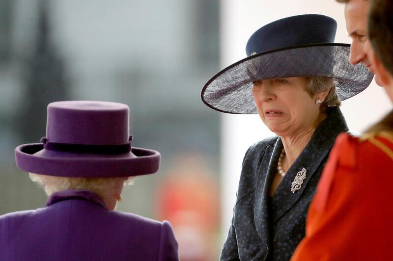Britain's Prime Minister Theresa May talks to Queen Elizabeth as they wait to greet King Willem-Alexander and his wife Queen Maxima of the Netherlands at a Ceremonial Welcome during a state visit. Matt Dunham / AFP