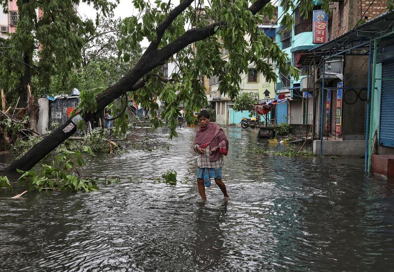 A man crosses a flooded street after cyclone Amphan made its landfall, in Kolkata, India. Reuters