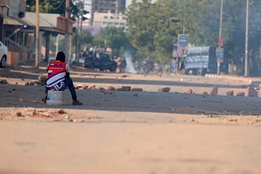 A protester sits in a street facing security forces at a demonstration, in Khartoum. Protesters have taken to the streets in the capital and across the country over dire living conditions. AP
