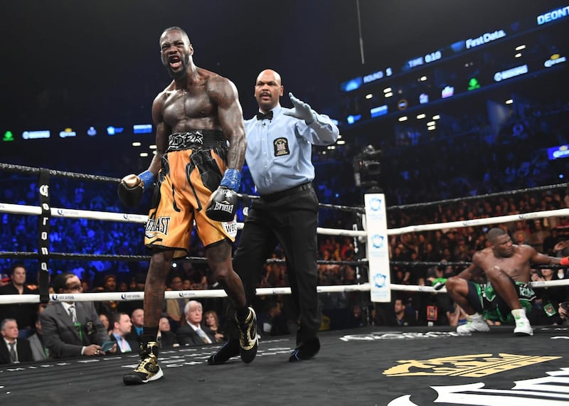 WBC heavyweight champion Deontay Wilder celebrates knocking down undefeated contender Luis “King Kong” Ortiz (R) during their 12-round WBC Heavyweight Championship fight at the Barclays Center in Brooklyn, New York March 3, 2018. / AFP PHOTO / TIMOTHY A. CLARY