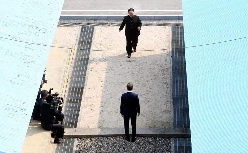 North Korean leader Kim Jong-un, top, walks towards South Korean president Moon Jae-in, bottom, at the border village of Panmunjom. Korea Summit Press Pool via AP
