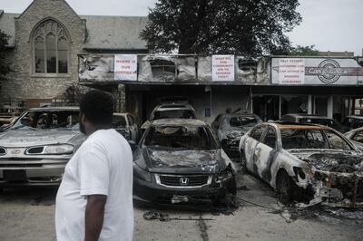 A resident inspects burned out cars at a used car dealership in Kenosha, Wisconsin, U.S., on Tuesday, Sept. 1, 2020. Donald Trump lauded police and National Guard members in Kenosha, Wisconsin, on Tuesday, where the shooting of a Black man by police last month has reignited national protests against racial inequality and street violence the president has sought to blame on Democrats. Photographer: Matthew Hatcher/Bloomberg