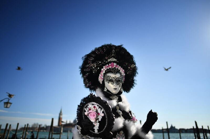 A reveller wearing a mask and a period costume takes part in the Venice Carnival. AFP