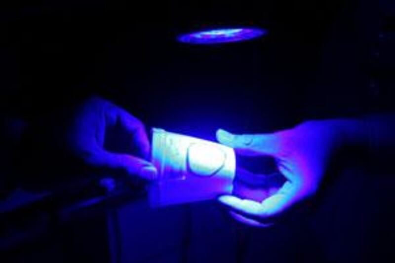 An ultraviolet light is used to illuminate fingerprints at Forensic Science Department in Abu Dhabi.