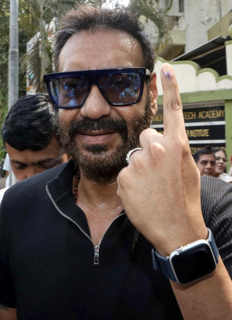 Bollywood actor and director Ajay Devgn poses for photographs as he leaves a polling station after casting his vote in Mumbai on April 29, 2019. AFP