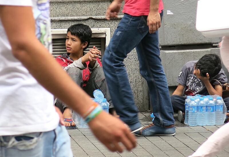 Dom Gypsy boys take a break from selling water on Istanbul’s Taksim Square. Many Dom children, refugees of Syria’s war, beg but those who can, sell water instead. Dan Boylan for The National / September 22, 2014