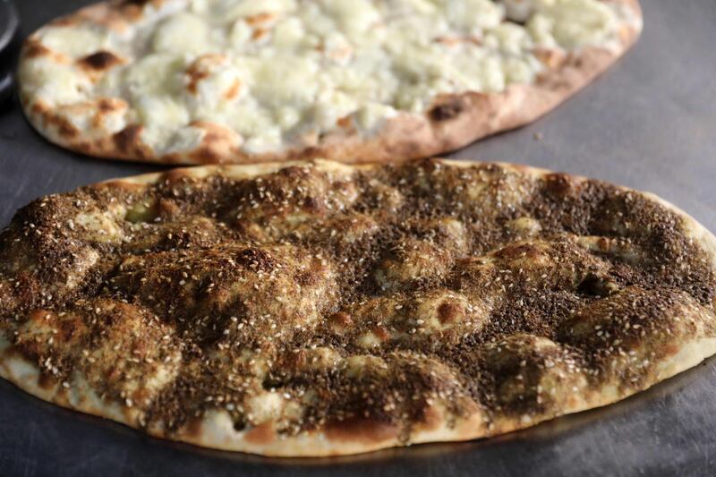 Freshly baked flatbread garnished with thyme and cheese ready to be served at Abu Shadi's bakery. The baker says many of his customers of three decades can no longer afford to buy his modest manousheh becuase of skyrocketing prices caused by inflation. AFP